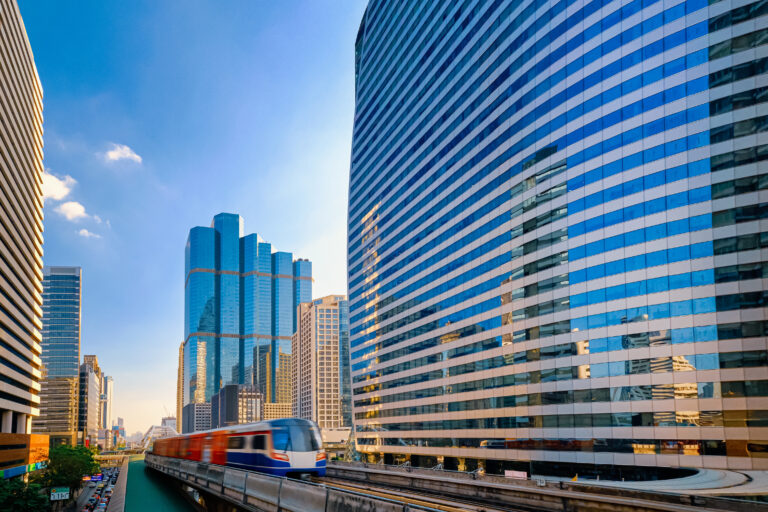 Train in motion blur in business downtown of modern city of skyscrapers.