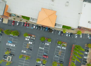 A parking lot with a lot of cars and a building in the background