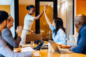 Diverse colleagues celebrating success in an office during a business meeting