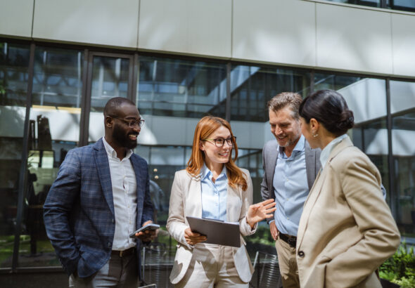 multiracial businesspeople review reports with business data charts