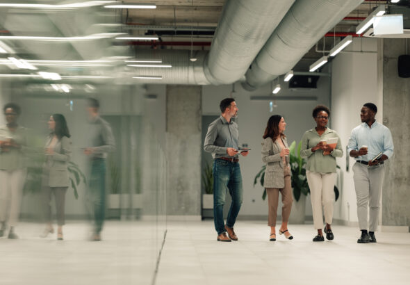 Diverse business team walking through modern office discussing work