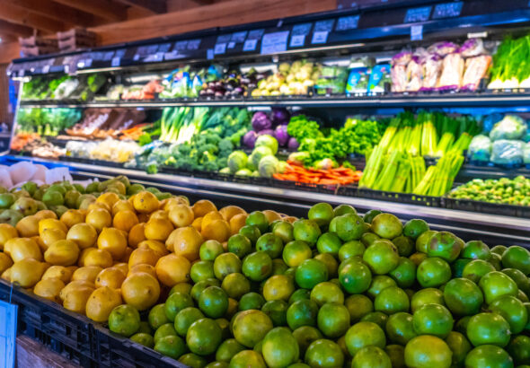 Fresh limes and lemons displayed in grocery store produce section