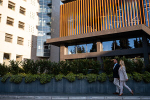 Business people walking past modern corporate building