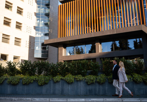 Business people walking past modern corporate building