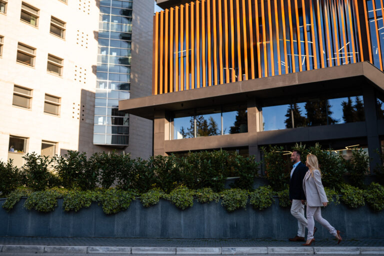 Business people walking past modern corporate building