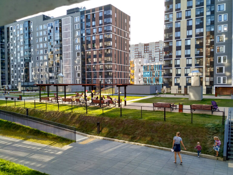 A group of people resting in new appartment district. New Moscow buildings