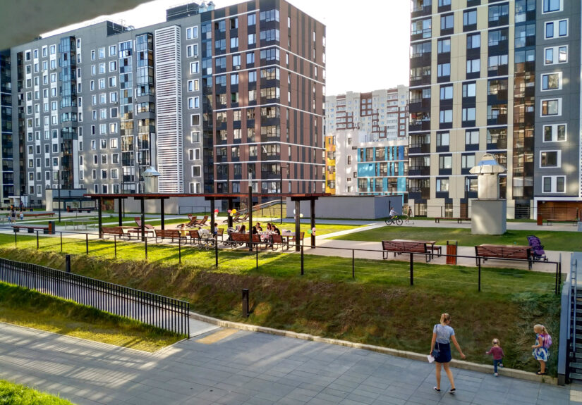 A group of people resting in new appartment district. New Moscow buildings